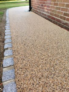 A resin bound stone surface with a natural granite sett edge, showcasing a seamless blend of durability and elegance.